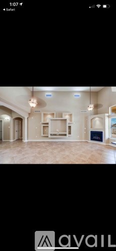 A room with a large open space and a kitchen area.