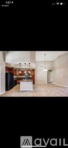 A room with a white table and a black refrigerator.