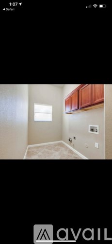 A room with a window and a brown cabinet.