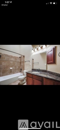A bathroom with a tub, toilet, and sink.