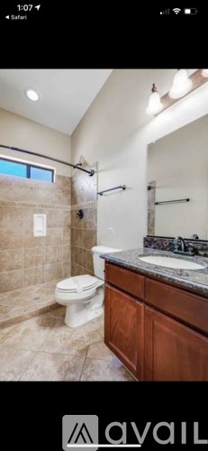 A bathroom with a toilet, sink, and shower area.