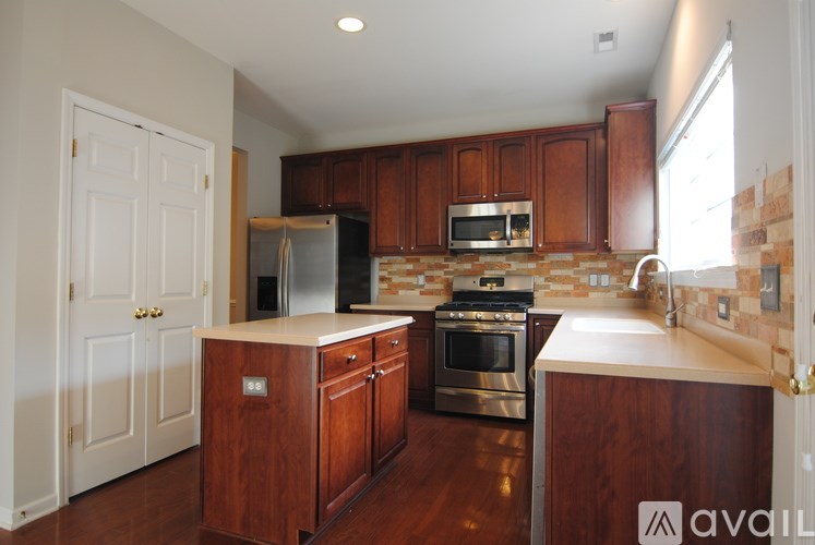A kitchen with wooden cabinets and a stainless steel oven.