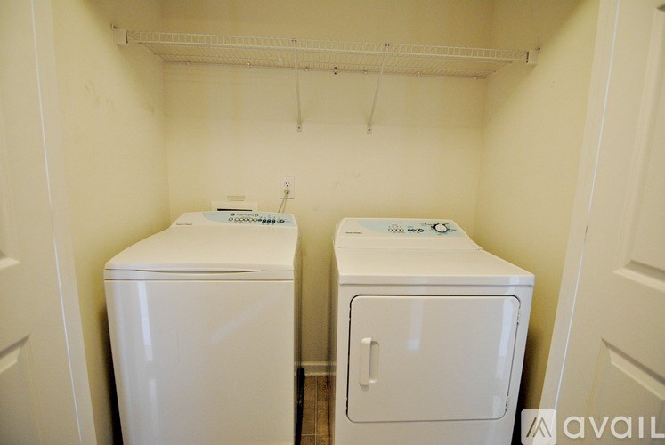 Two white washing machines in a small laundry room.