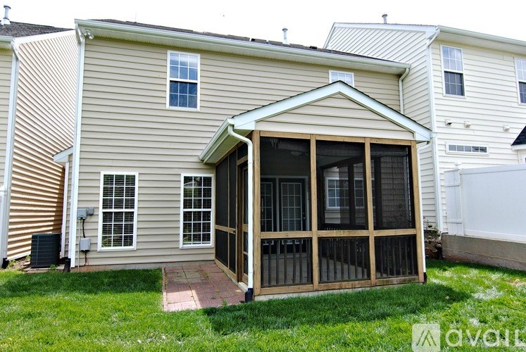 A house with a covered patio and a brick walkway.