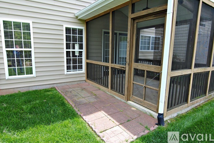 A patio area with a brick walkway and a sliding glass door.
