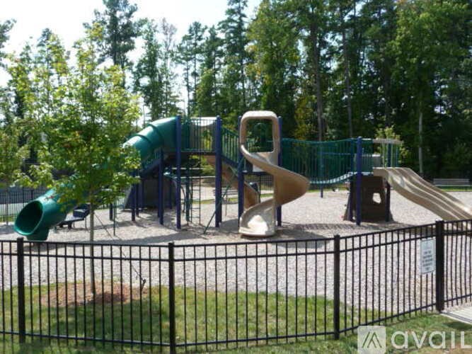 A playground with a green and yellow slide.