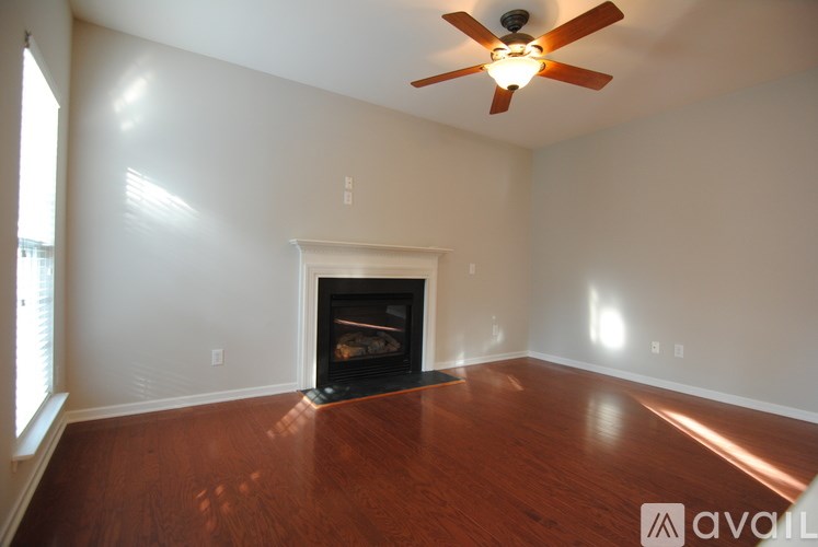 A room with a fireplace and a ceiling fan.