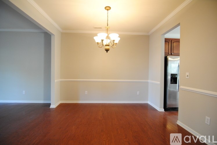A room with wooden floors and a chandelier hanging from the ceiling.