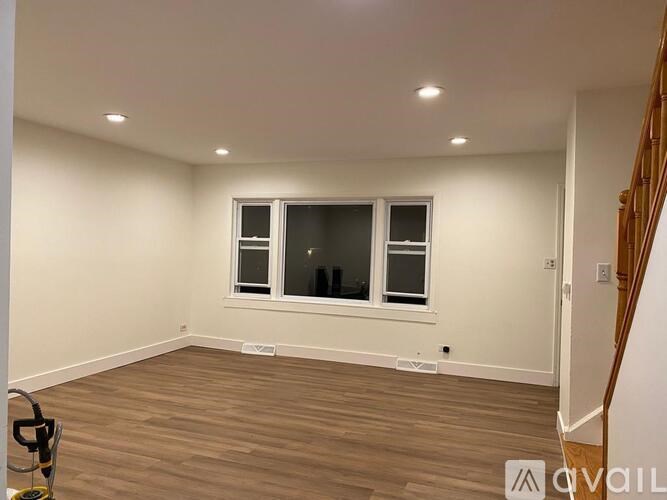 A room with a window and a vacant floor.