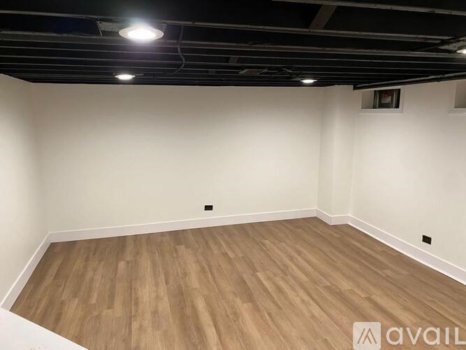 A room with wooden flooring and white walls.