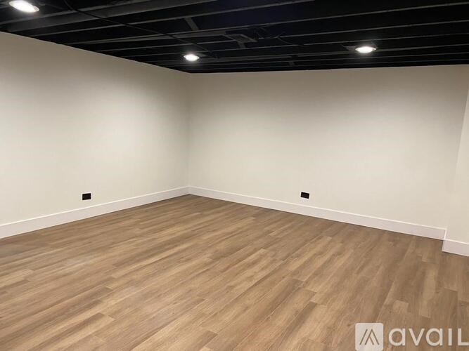 A room with wooden flooring and a black ceiling.