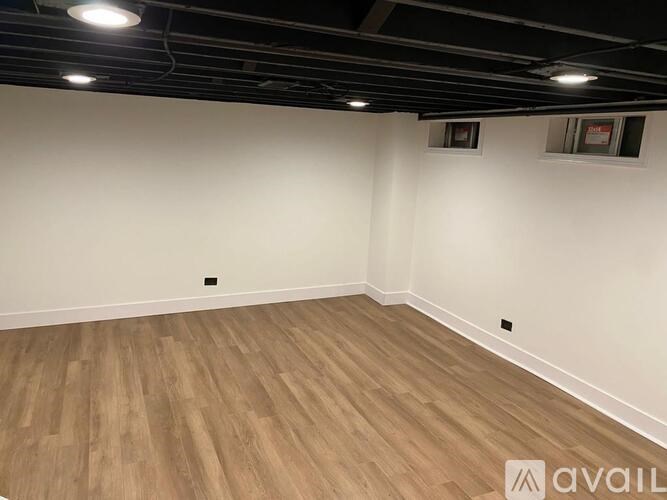 A room with wooden flooring and white walls.