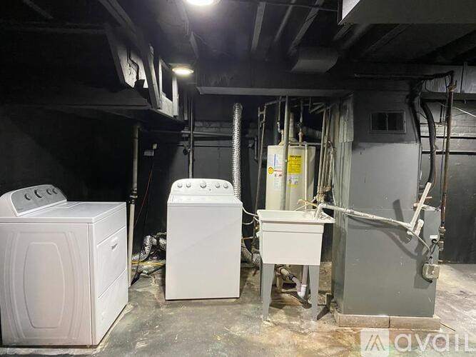 A room with a washing machine and a dryer.