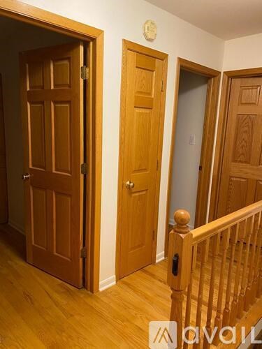 A room with a wooden door and a wooden staircase.