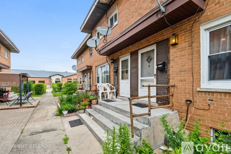 A red brick house with a white door and a small garden in front.