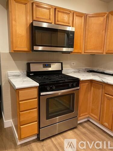 A kitchen with wooden cabinets and a black stove top oven.
