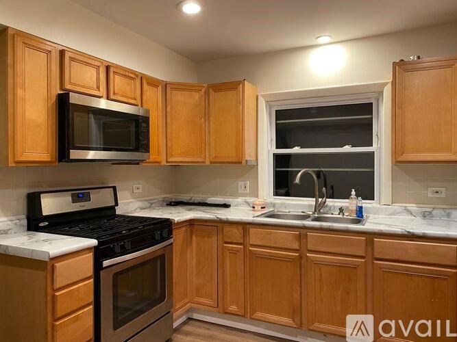A kitchen with wooden cabinets and a black stove top oven.