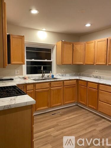 A kitchen with wooden cabinets and a marble countertop.