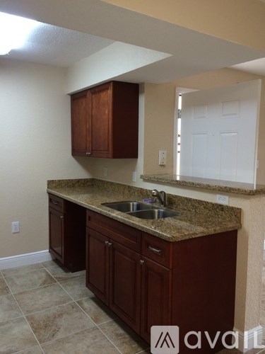 A kitchen with brown cabinets and a granite countertop.