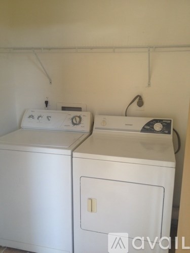 Two white front loading washing machines in a laundry room.