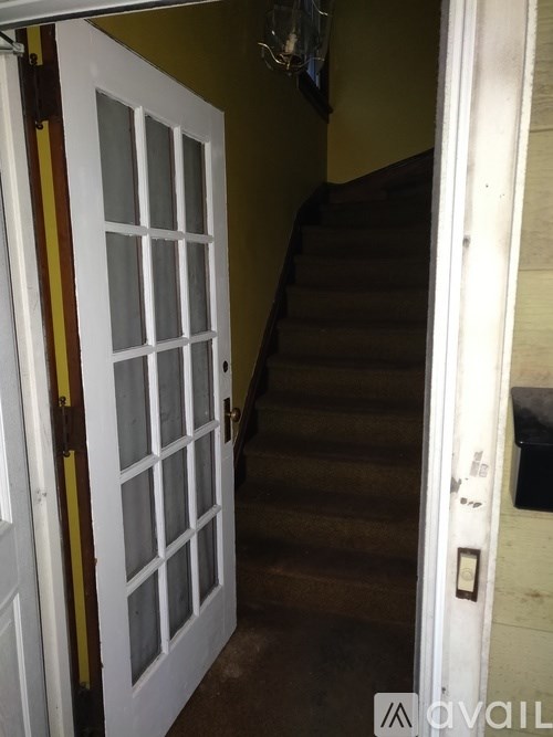 A white door with a yellow stripe on the side is open.
