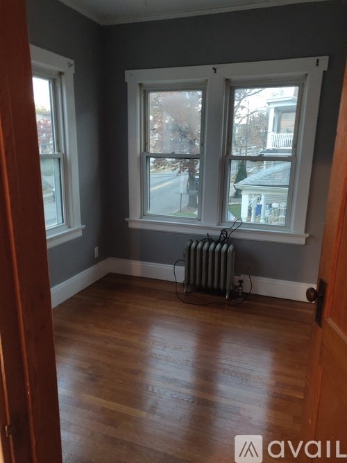 A room with a window and a radiator on the floor.