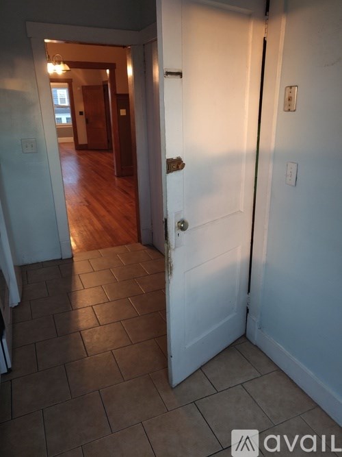A hallway with a white door and a brown floor.