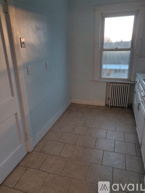 A room with a window and a radiator on the wall.