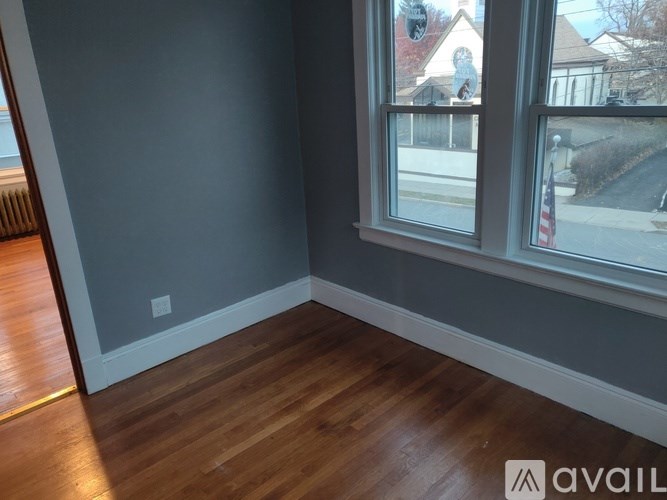 A room with a window and wooden flooring.