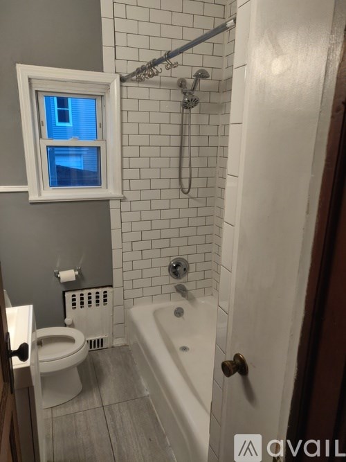 A bathroom with a white tub, toilet, and sink.