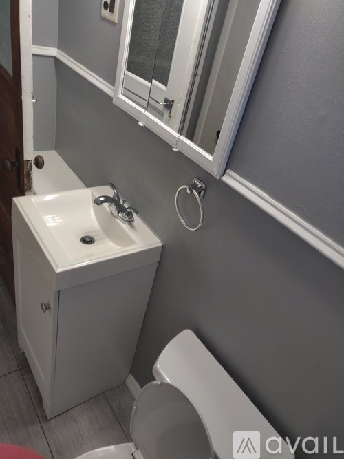 A white sink with a silver faucet is mounted on a white cabinet in a bathroom.