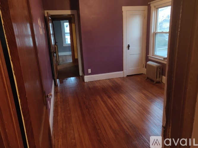 A room with purple walls and wooden floors.