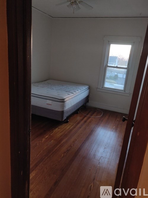 A bedroom with a bed and a window.