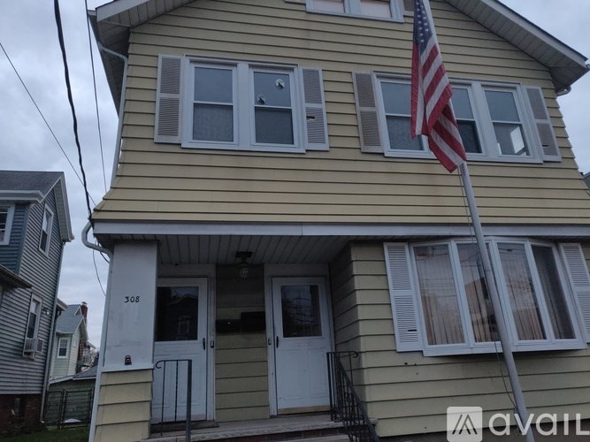 A yellow house with a flag on the front.
