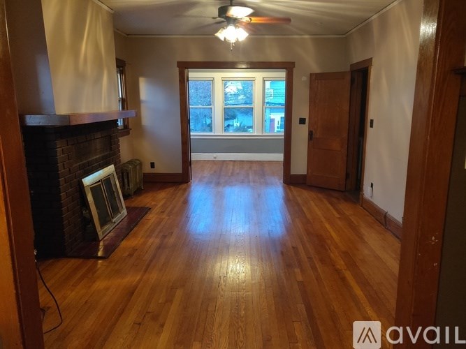 A room with wooden floors and a fireplace.