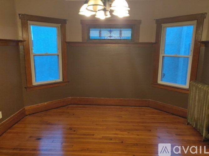 A room with wooden floors and two windows.