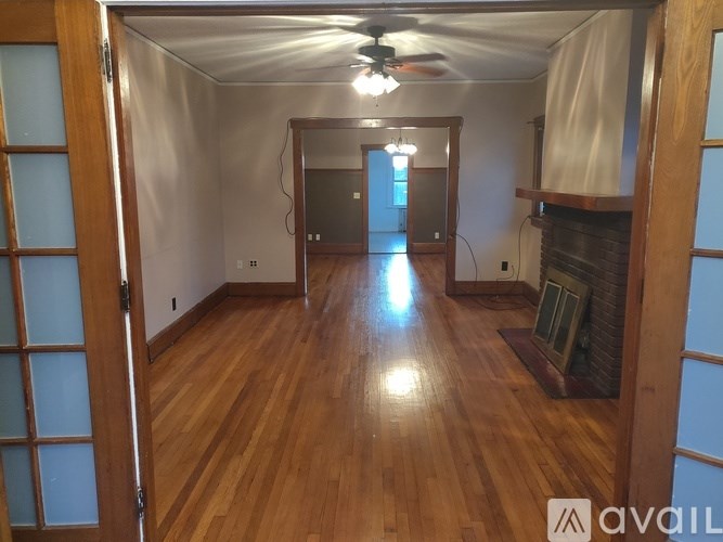 A room with wooden floors and a fireplace.