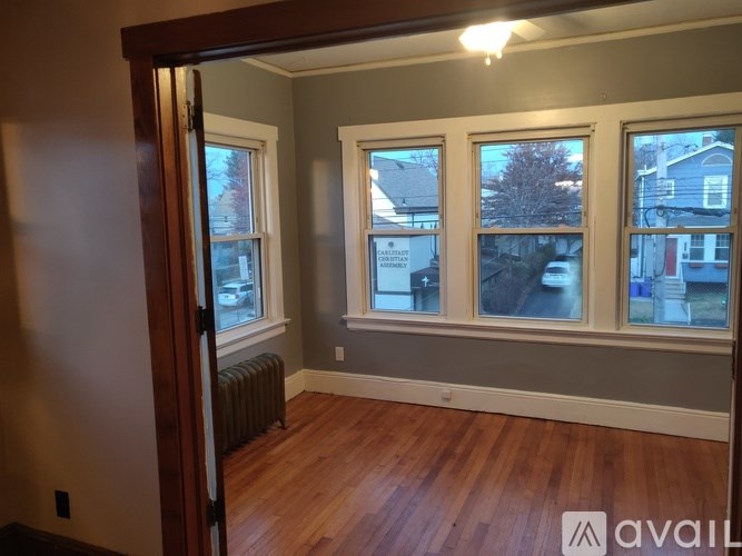 A room with wooden floors and three windows.