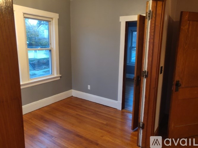 A room with a wooden floor and a window.