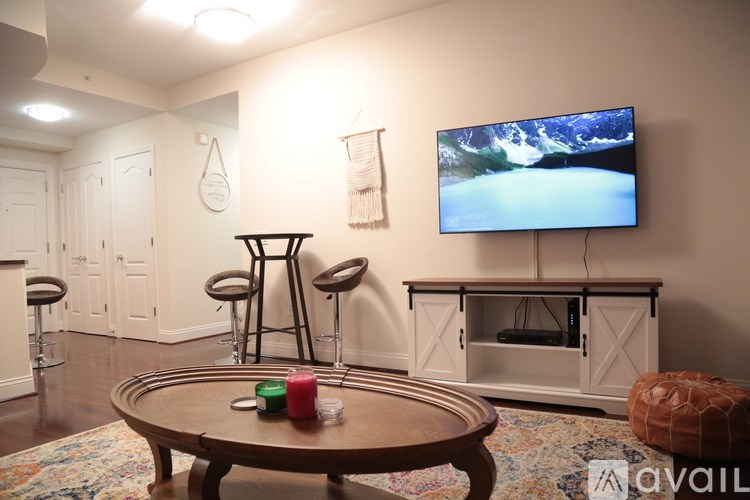A living room with a wooden coffee table and a flat screen TV mounted on the wall.