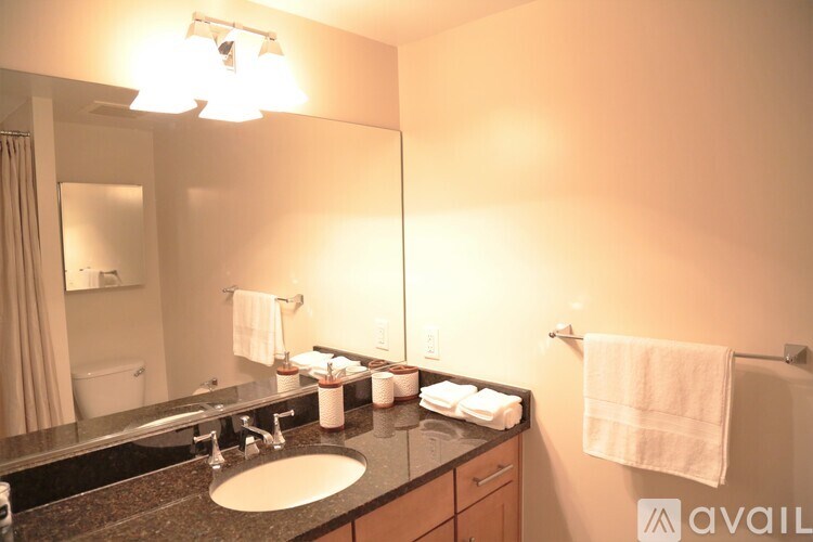 A bathroom with a sink, mirror, and towel rack.