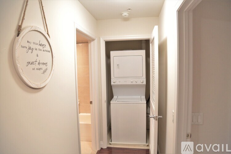 A white fridge is in a narrow hallway.