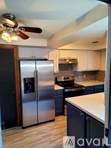 A kitchen with a stainless steel refrigerator and a ceiling fan.