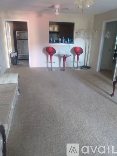 A living room with a grey carpet and a white sofa.
