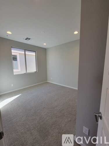 A room with a carpeted floor and a window.
