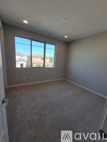A room with a large window and a carpeted floor.