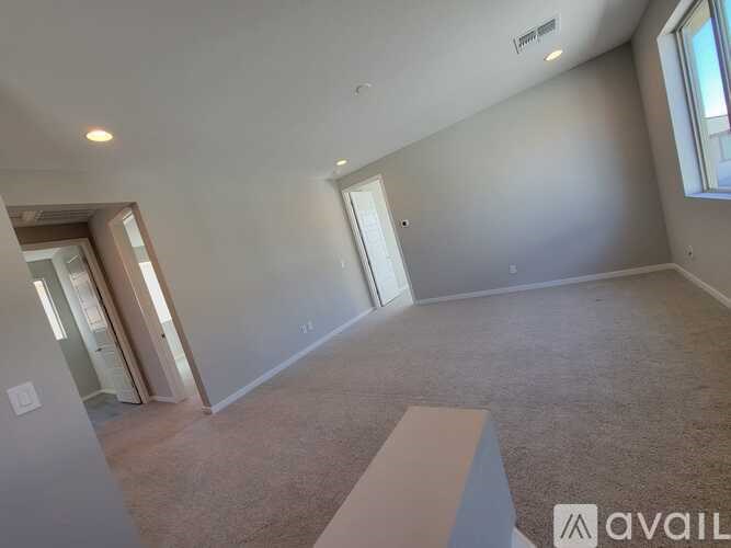 A room with a carpeted floor and a window on the wall.