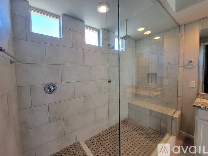 A bathroom with a walk-in shower and a window.