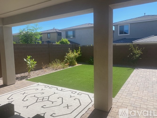 A backyard with a lawn and a patterned rug.