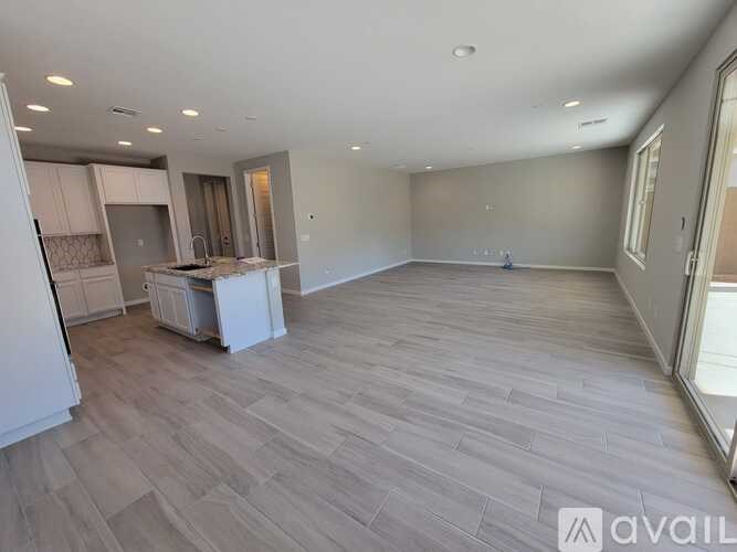 A spacious room with light grey flooring and white walls.